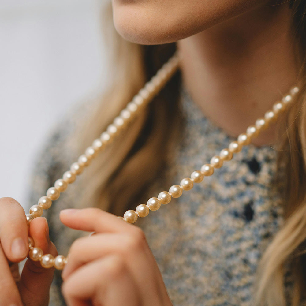 A woman gracefully adorned with a freshwater pearl necklace, exuding elegance and sophistication.