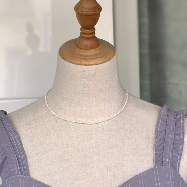 2-3mm Mini Pearl Necklace displayed on a mannequin stand